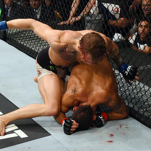 LAS VEGAS, NV - JULY 11: Conor McGregor (top) punches Chad Mendes in their UFC interim featherweight title fight during the UFC 189 event inside MGM Grand Garden Arena on July 11, 2015 in Las Vegas, Nevada. (Photo by Josh Hedges/Zuffa LLC/Zuffa LLC via Getty Images)